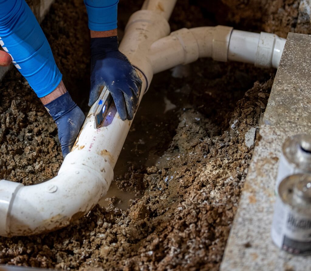 Plumber repairing slab leak pipe