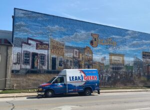 Leak Geeks plumbing van in front of a Justin, TX mural
