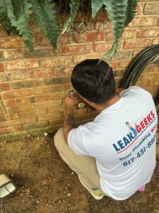Leak Geeks plumber working on a hose bib in Keller