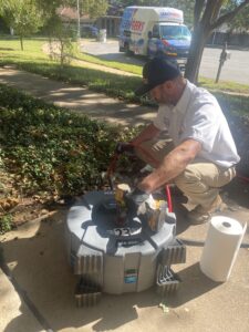 Plumber using a drain machine to clear a root intrusion