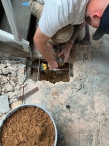 Plumber prepping a copper pipe for a repair under a slab