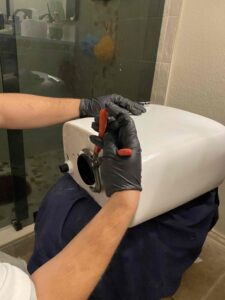Toilet tank flush valve being replaced in Fort Worth